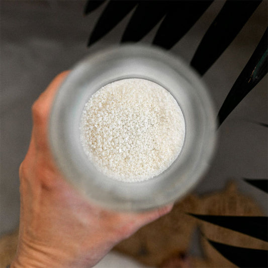 Lessive en poudre bio à diluer avec de l'eau chaude dans la bouteille en verre fournie