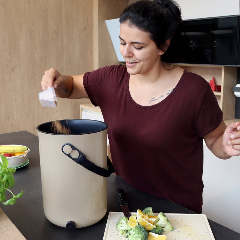 versez l'activateur dans le composteur d'appartement pour accélérer la fermentation du compost