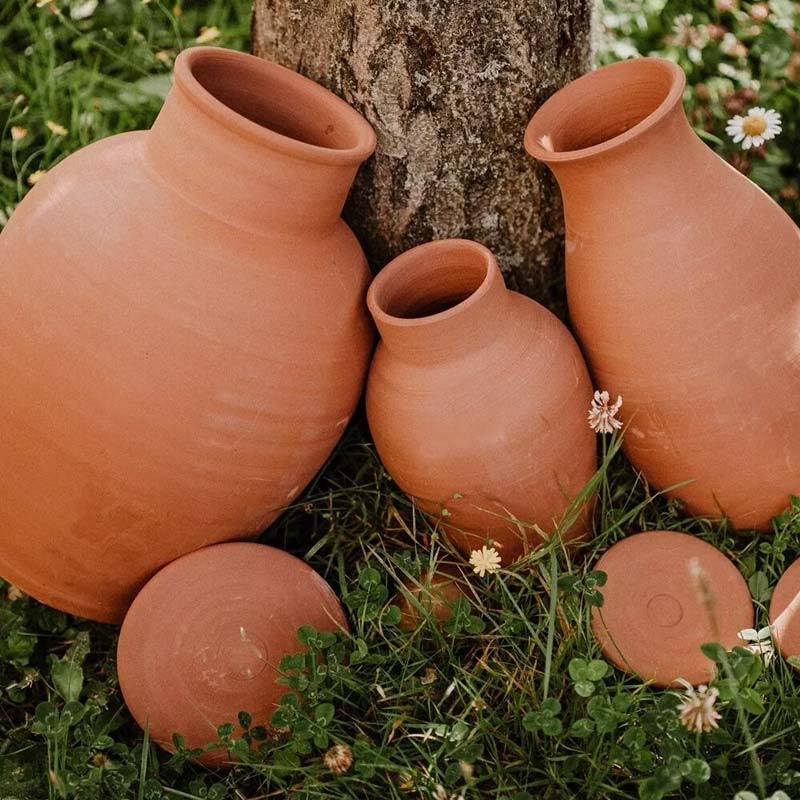 Plusieurs tailles d'oyas en terre cuite à enterrée pour irriguer naturellement les plantes et réduire les besoins en arrosage